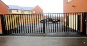 C13 Commercial automated gate on underground hydraulic gate motors with horizontal and vertical saftey edges and a electronic gate lock. Sheffield South Yorkshire.